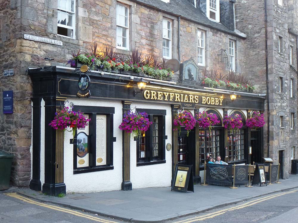 Blooming hanging baskets bursting with colourful plants and flowers at the Greyfriars Bobby Bar in Edinburgh’s Old Town