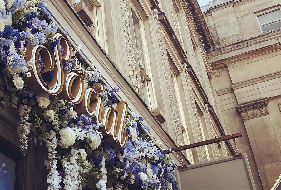 The Social in Glasgow with bespoke signage and a floral frontage of purple and white hydrangea and wisteria flowers